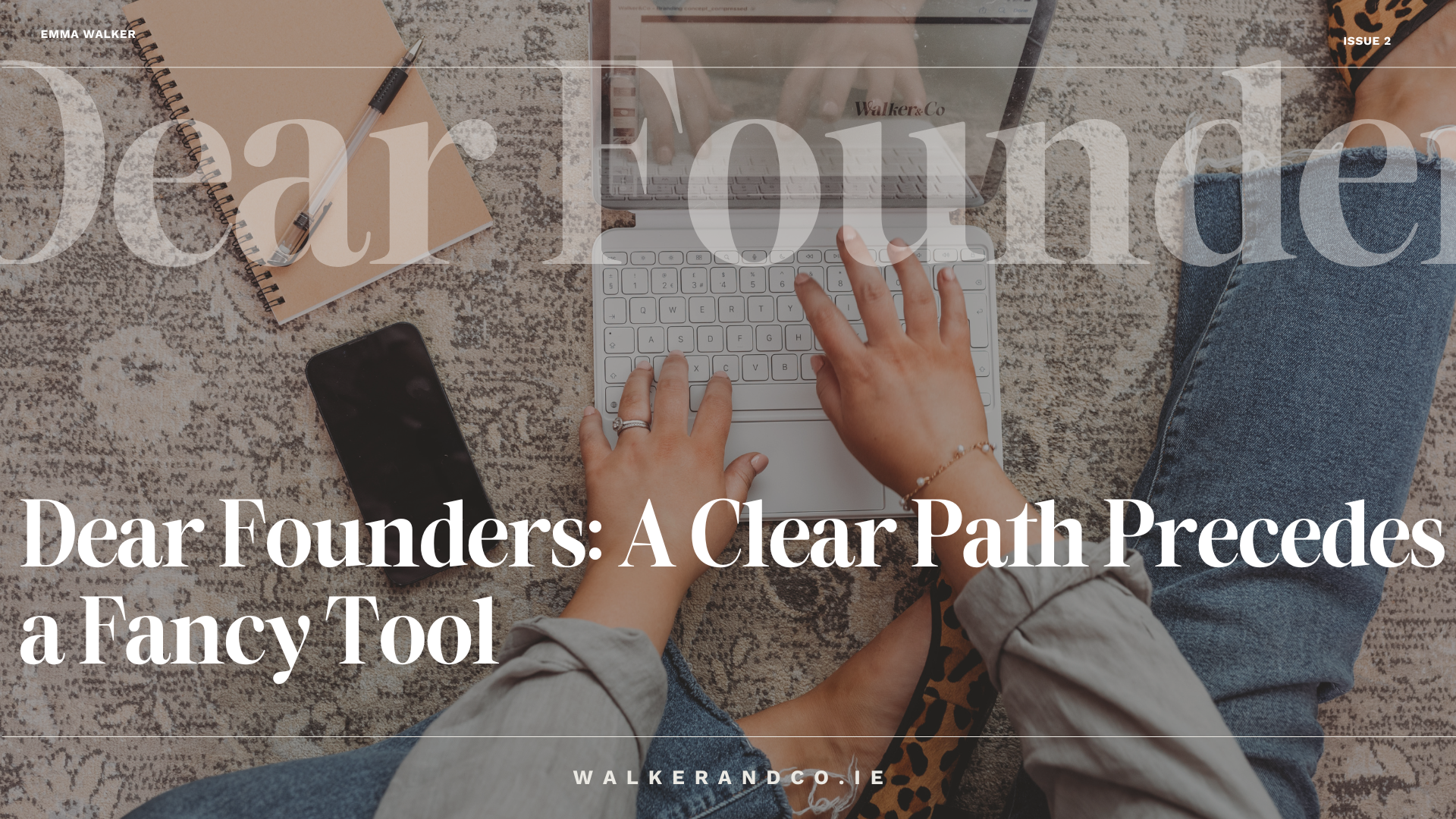 Hands typing on a white keyboard placed on a patterned rug, with a notebook and phone nearby. Overlaid text reads: “Dear Founders: A Clear Path Precedes a Fancy Tool” with the website walkerandco.ie.